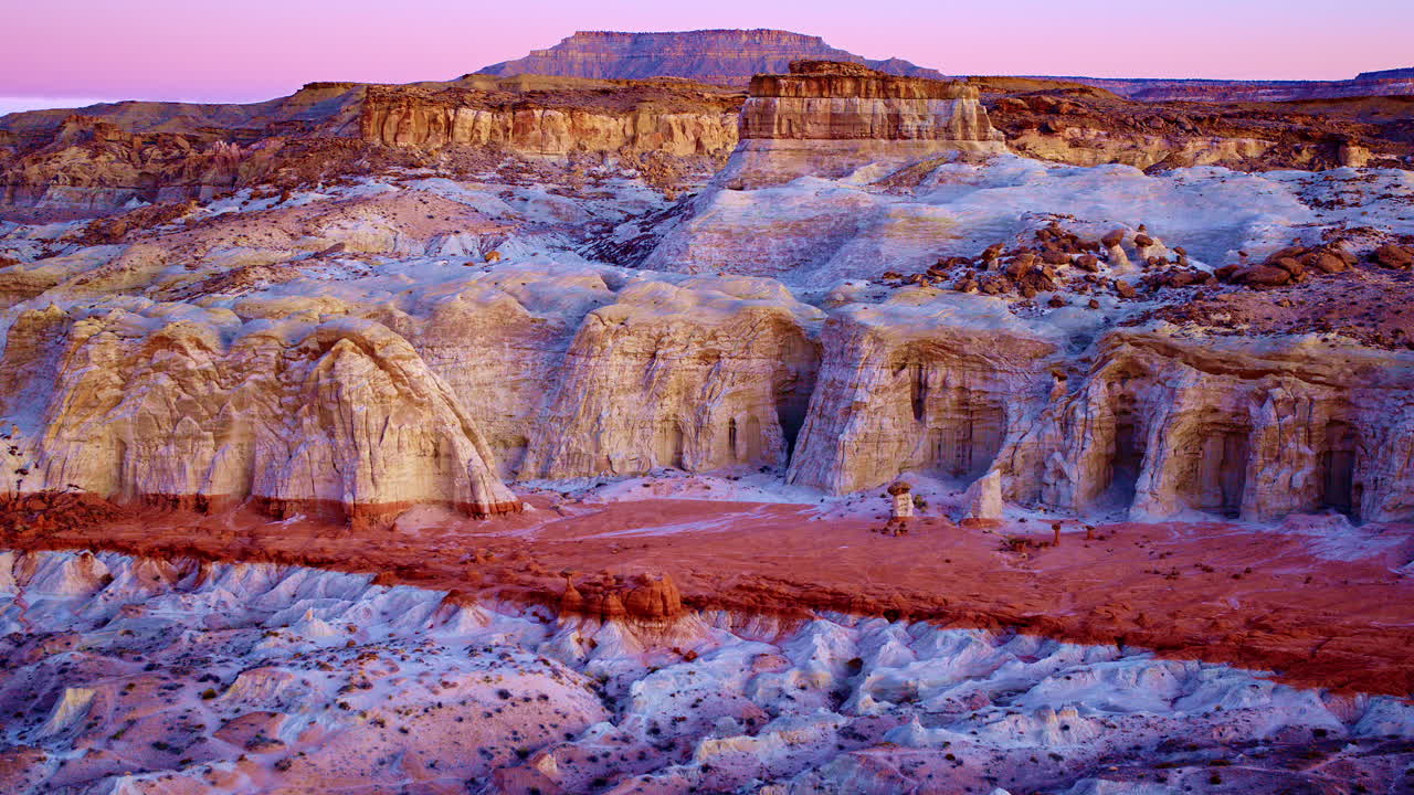 Sweeping aerial view of otherworldly hoodoos with rich textures and warm desert tones.