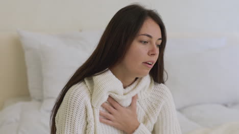 Mujer-Enferma-Tosiendo-Sentada-En-La-Cama-Sola-En-Casa