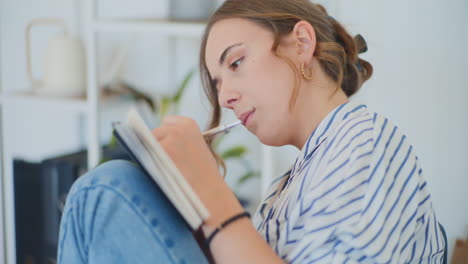 mujer escribiendo notas en casa