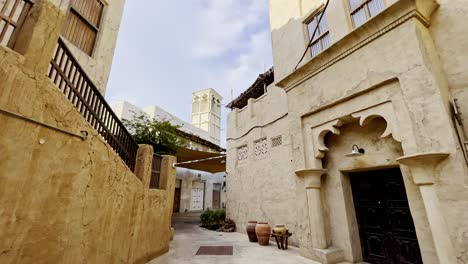 Viejos-Edificios-Residenciales-Con-Torre-De-Viento-Tradicional-A-Lo-Largo-De-Un-Callejón-Estrecho-En-El-Distrito-Histórico-De-Al-Fahidi-En-Dubai,-Emiratos-árabes-Unidos