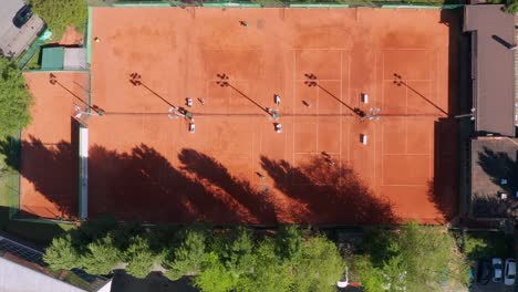 top view of people playing tennis at an outdoor tennis court in novi sad, serbia on a sunny morning