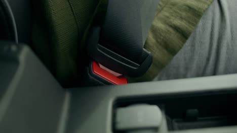 person fastening a seatbelt in a car