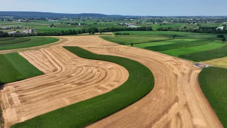 An-aerial-view-over-the-lush-green-farmland-in-southern-Lancaster-County,-Pennsylvania-on-a-sunny-summer-day