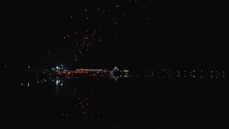 sky lanterns over a city at night