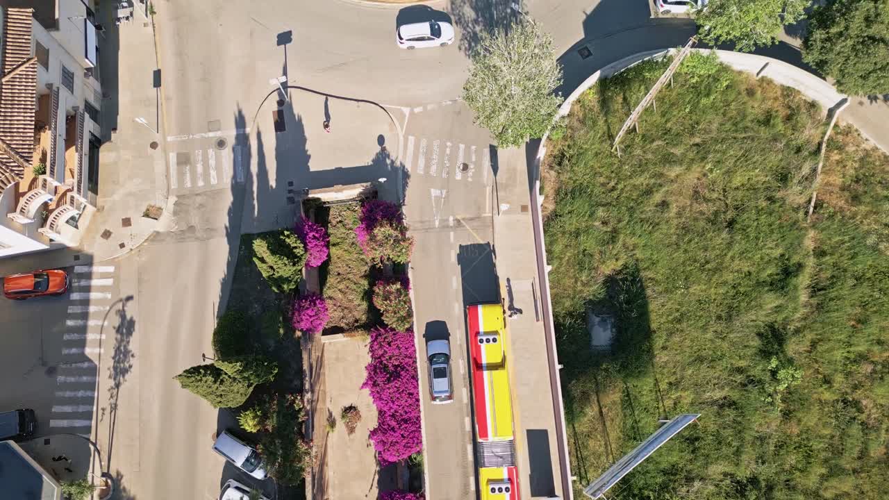 A bird's-eye view captures cars navigating through the bustling streets of Manacor, Spain, highlighting the city's dynamic urban layout.