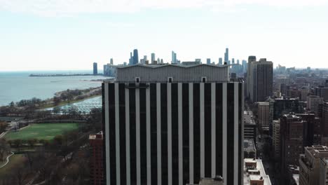 chicago downtown and belmont harbor emerges from behind a high-rise apartment building on sunny autumn day