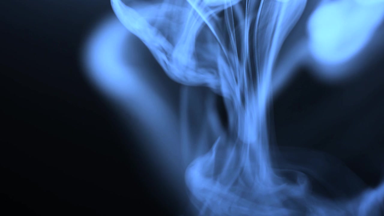 Fumo blu vorticoso in un ambiente scuro.