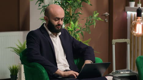 middle eastern man typing on laptop