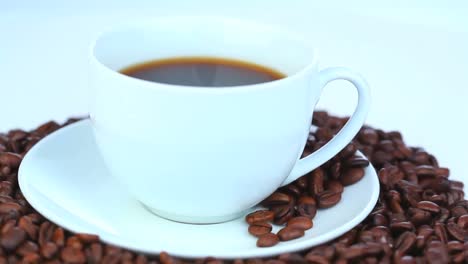 cup of coffee with coffee beans rotating