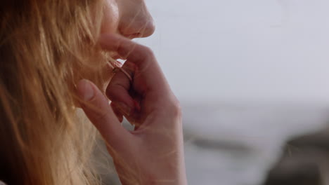 retrato de cerca de una mujer hermosa sonriendo disfrutando de la playa relajándose en la orilla del mar el viento soplando el cabello explorando un estilo de vida tranquilo y despreocupado