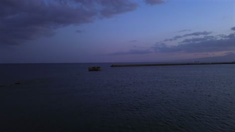 aerial , low altitude, fast push in footage, flying towards iconic light house and one kilometer pier, at port of kalamata, on a cloudy spring afternoon 4k