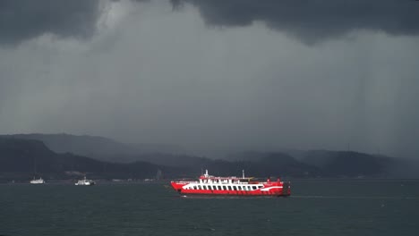 어두운 비 폭풍 앞에 섬을 향해 항해하는 여객 페리, 느린 모션, 동 자바, 인도네시아