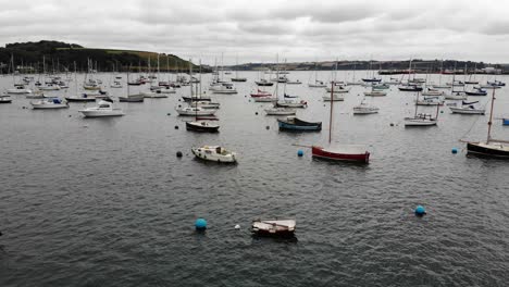 aerial forward shot flying over moored boat in falmouth harbour cornwall