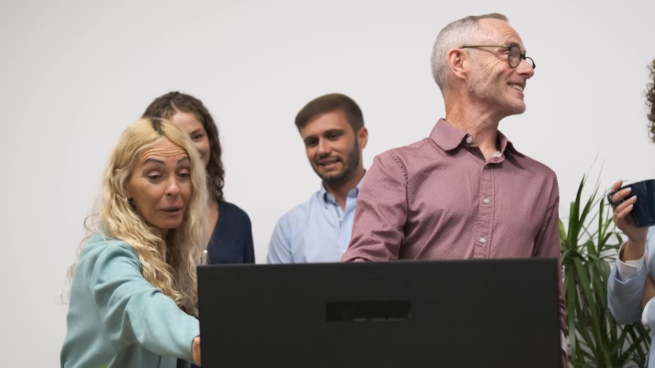 Happy mature male manager discussing strategy with team in office