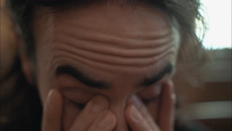 스트레스를 받고 슬픈 남자가 감정적 고통 속에서 얼굴을 문지르고