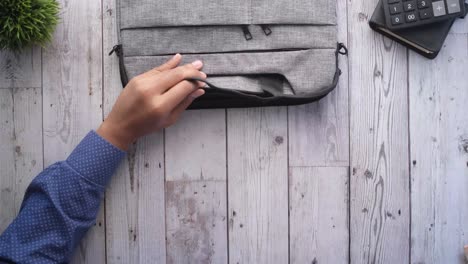 person packing a laptop bag