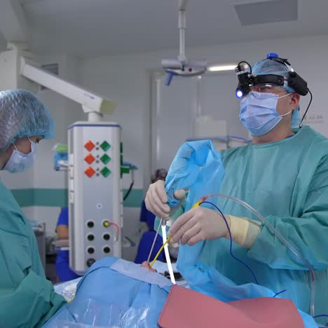 operating surgeon wearing special equipment on his head in the surgery room. doctor observes the operation running on the screen. surgeon applies medical tools to the patient