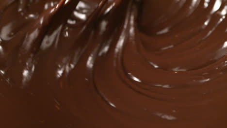 mixing melted liquid dark chocolate with a whisk