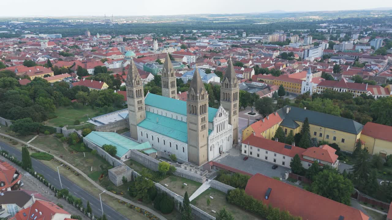 Aerial of Pécs Cathedral in Hungary, set against the backdrop of rooftops and the wider city