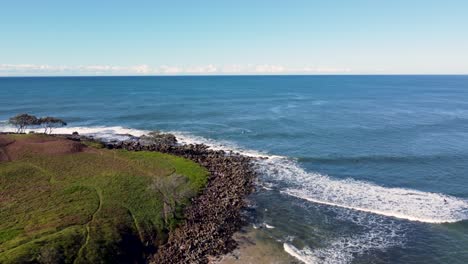 Toma-Panorámica-Aérea-De-Drones-De-La-Alineación-De-Surfistas-Arrecife-Paisaje-Rocoso-Paisaje-Naturaleza-Isla-Yamba-Angourie-Promontorio-Nsw-Costa-Norte-Australia-4k