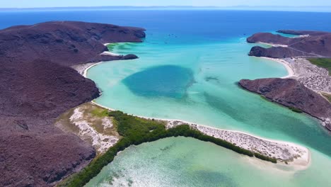 antena voladora hacia atrás de agua turquesa y playas con laguna de río manglar y océano abierto distante