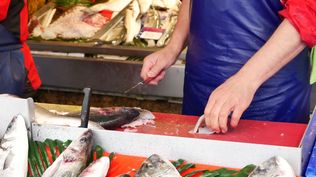 시장 에서 물고기를 필레팅 하는 물고기 판매자