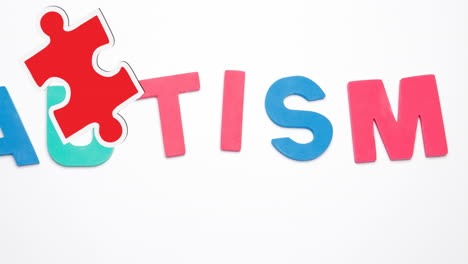 animation of autism text with puzzle pieces on white background