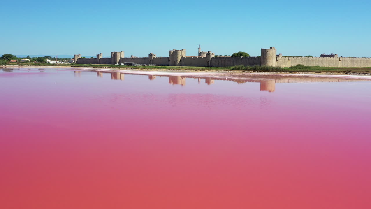 la ciudad histórica de aigues-mortes en la camarga, francia durante un día soleado de verano que se encuentra junto a un lago de sal rosa