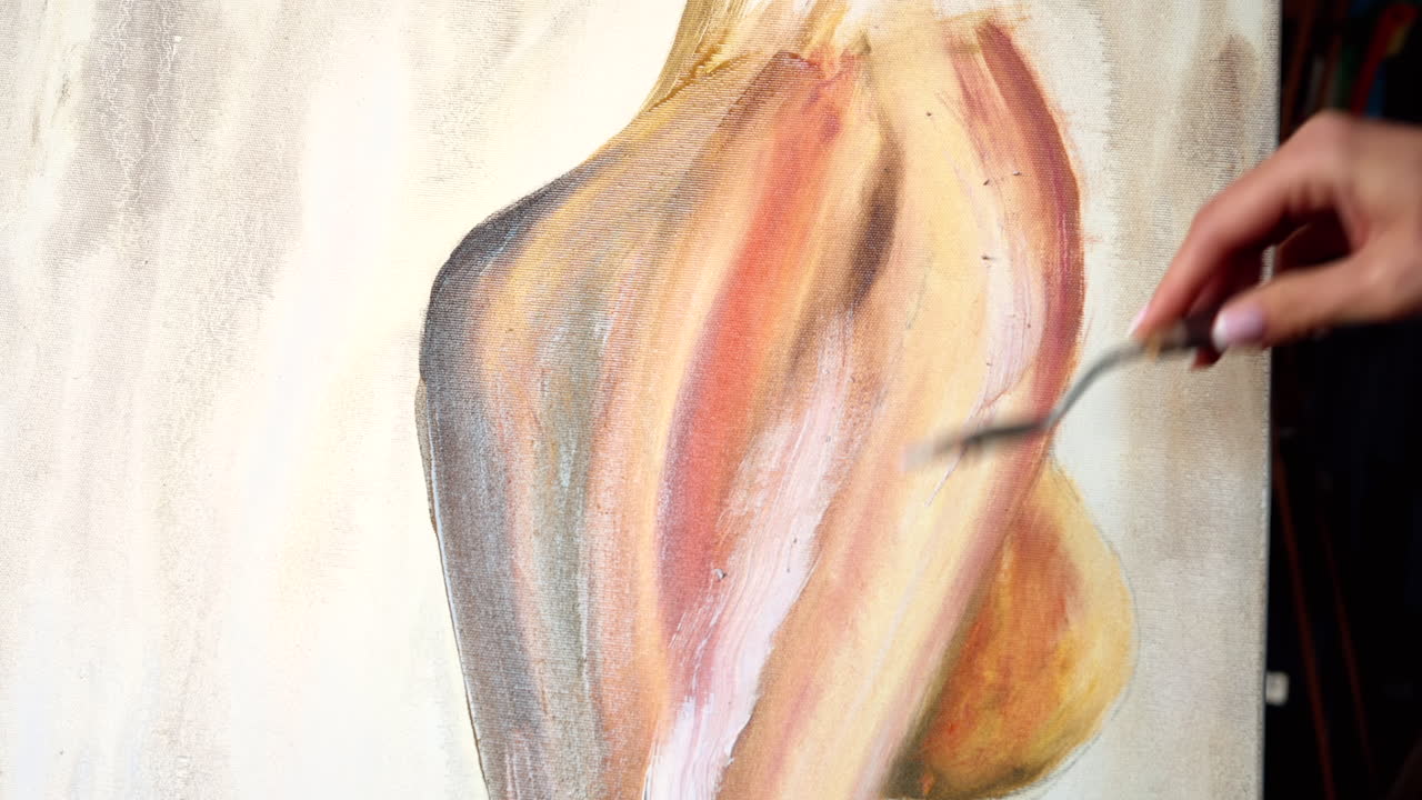 Close up of a woman painting on a canvas at an art gallery workshop