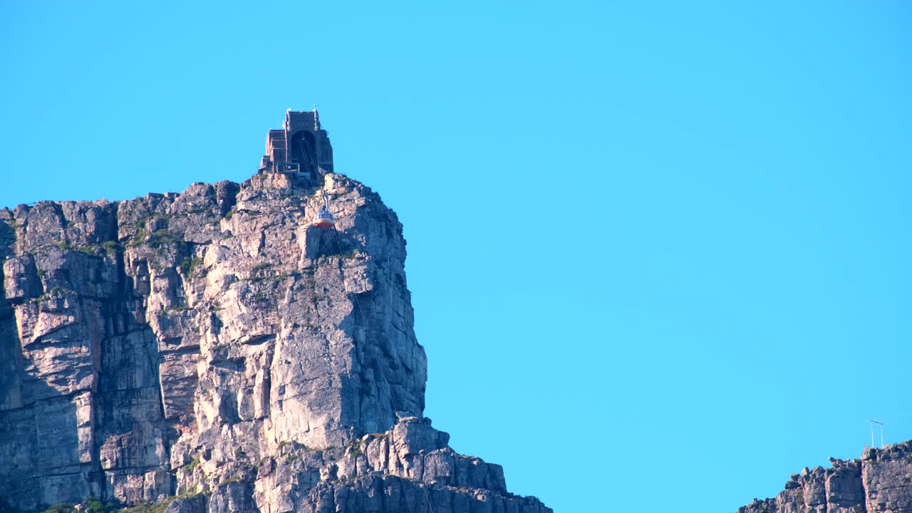 Table Mountain aerial cableway cable car descending from top, telephoto