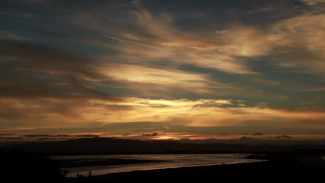 stunning peaceful whakatane golden sunset with illuminated clouds, pan down