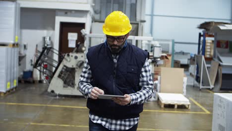 confident mature factory worker using tablet