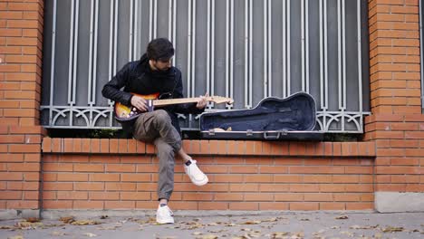 el tipo tocando la guitarra al aire libre