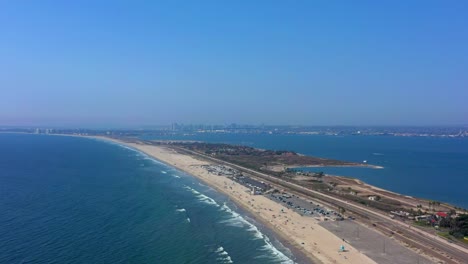 Side-panning-shot-of-Coronado-beach-in-San-Diego-California-with-clear-blue-sky-and-the-beautiful-pacific-ocean-and-San-Diego-Bay