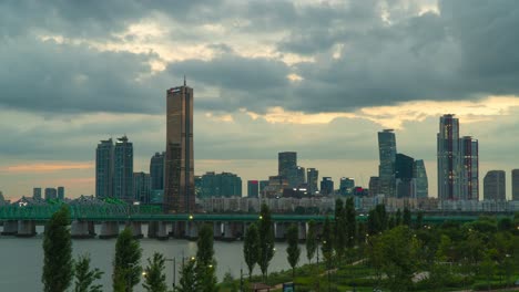 63 building tower and skyscrapers at sunset from han river park in seoul, south korea