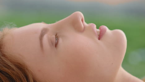 retrato en primer plano de una mujer hermosa acostada en la hierba en un tranquilo campo disfrutando de las vacaciones de verano relajándose en la naturaleza
