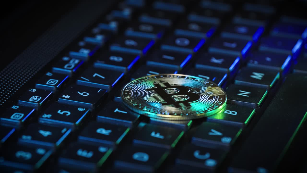 Bitcoin Golden coin lying On a Backlight RGB Keyboard, crypto technology concept
