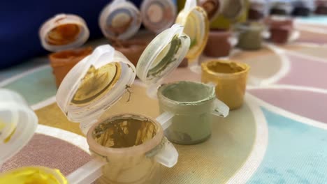 Close-up-shot-of-brush-dipping-in-painting-tubes-before-painting-on-a-canvas