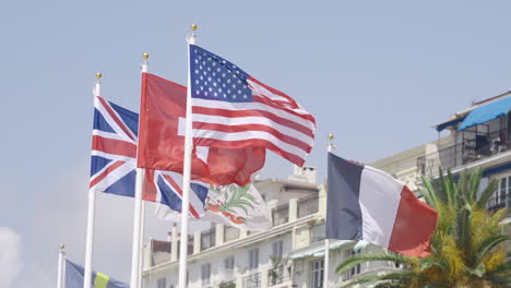 flags of several nations flying in a coastal town