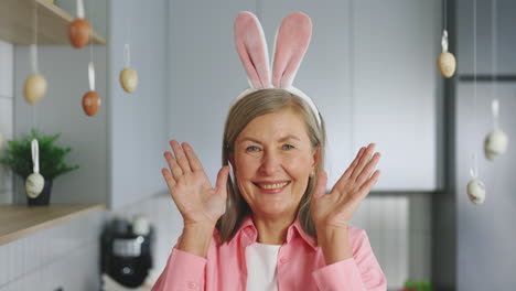 happy senior woman wearing bunny ears for easter