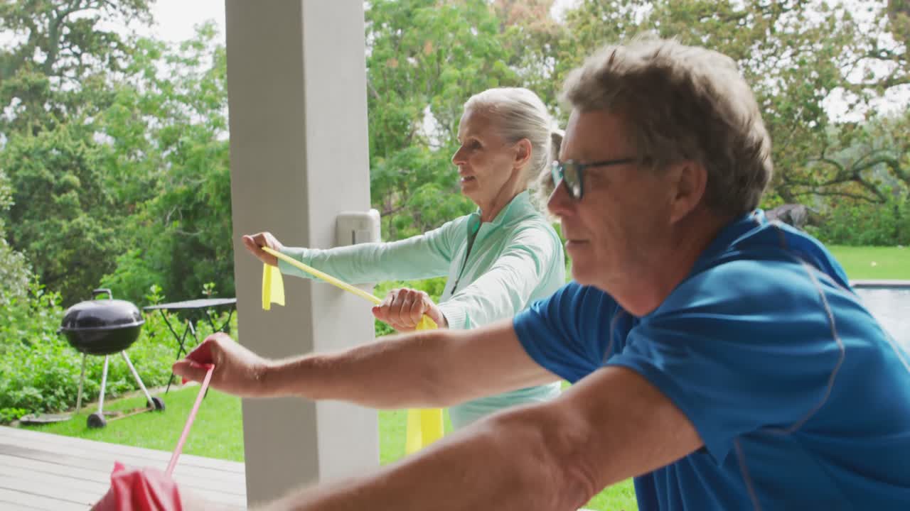 pareja de ancianos haciendo ejercicio en un jardín