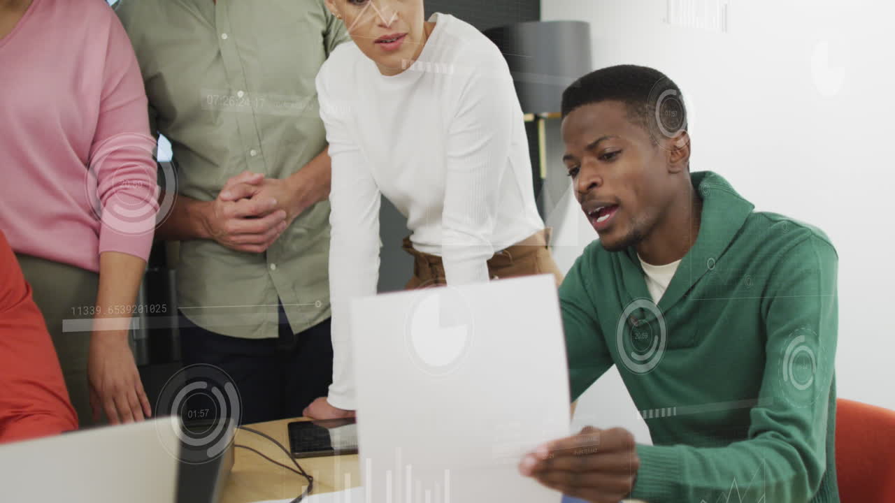 Animation of graphs, loading circles and bars over diverse man explaining reports to coworkers