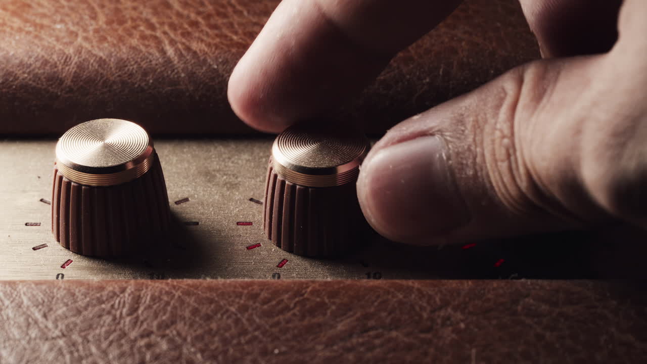 Close-up of a hand delicately tuning a vintage volume wheel, evoking nostalgia and craftsmanship. Perfect for retro, music, or tech-themed projects