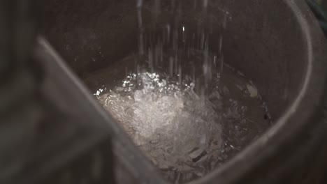water dripping into a garden fountain from washed vegetables , close up
