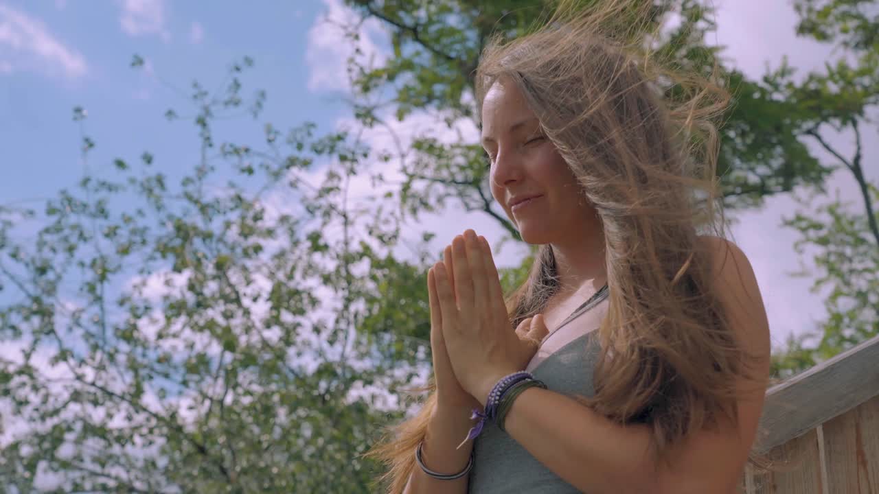 바람이 부는 날에 야외에서 명상하는 젊은 예쁜 여자의 근접 촬영 초상화