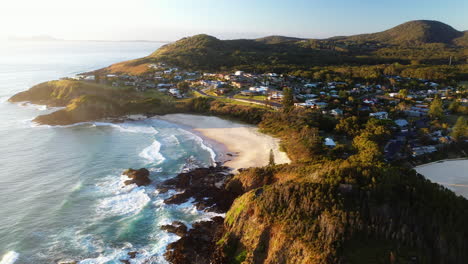 cinematic lowering drone shot of scotts head beach and town in australia