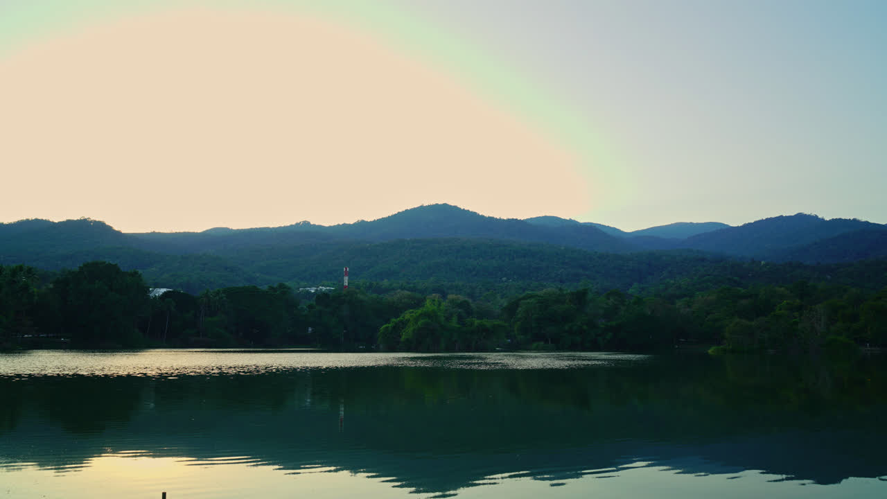 숲이 우거진 산과 황혼의 하늘이 있는 치앙마이 대학의 저속 앙케우 호수