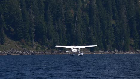 seaplane aterrizando sobre el lago de agua azul en la columbia británica, canadá