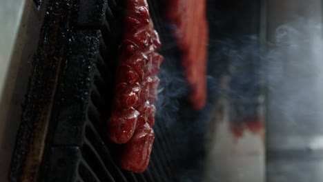 Close-Up-View-of-Smoking-Hot-Dogs-on-the-Grill