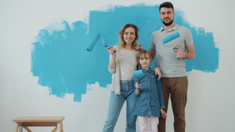 happy family painting a wall blue